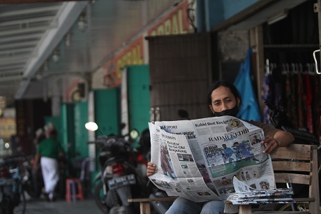 TERIK MATAHARI: Bukana Armanto saat hendak mengirimkan koran Jawa Pos Radar Kediri di sekitar Jalan Anjasmoro, Kelurahan/Kecamatan Pare, Kabupaten Kediri. (Foto: Iqbal Syahroni)