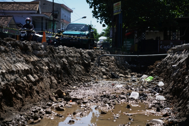 BUANG SEDIMEN: Satu unit alat berat mengeruk sampah dan pasir di saluran air Jl Dr Saharjo, Kelurahan Campurejo. (Foto: Wahyu Adji)