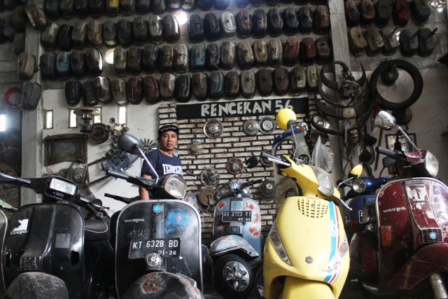 LANGKA: Musafa memeriksa vespa di Basecamp Rencekan 56 miliknya. Tiap hari banyak scooterist yang datang ke sana untuk memperbaiki motor mereka. (Foto: Iqbal Syahroni)