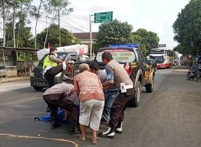 NAHAS: Petugas kepolisian dibantu warga mengevakuasi korban kecelakaan sepeda motor yang tergeletak di tengah jalan depan kantor Desa Branggahan, Kecamatan Ngadiluwih. (Foto: POLSEK NGADILUWIH for JPRK)