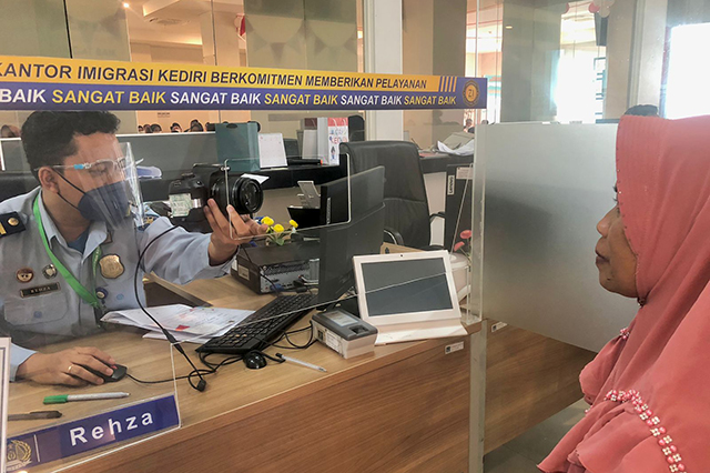 RESPONSIF: Petugas Kantor Imigrasi Kediri merekam data identitas pemohon paspor untuk bepergian ke mancanegara di kantornya, Bedrek, Desa/Kecamatan Grogol kemarin. (Foto: HUMAS KANTOR IMIGRASI KEDIRI )
