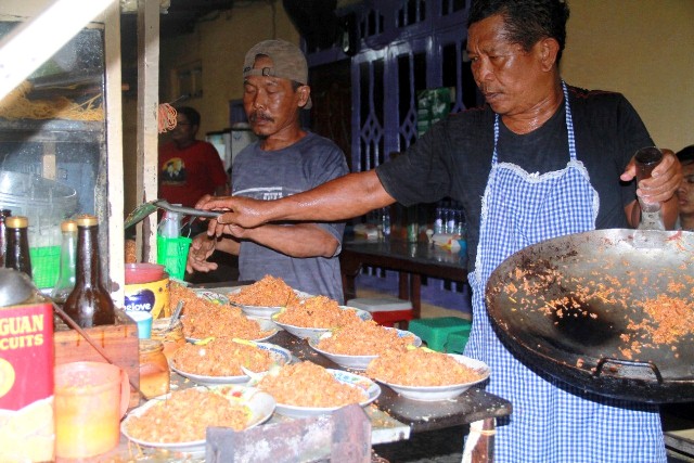 PORSI JUMBO: Pedagang nasi goreng dan mi goreng/mi kuah di Kampung Kuliner Lingkungan Cacingan, Kelurahan Jatirejo melayani pembeli. (Foto: Andhika Attar)