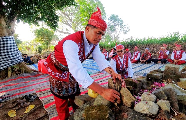 KHIDMAT: Kepala Desa Semen Mat Hasyim saat menyalakan dupa di makam sesepuh desa. (Foto: M. Arif Hanafi)