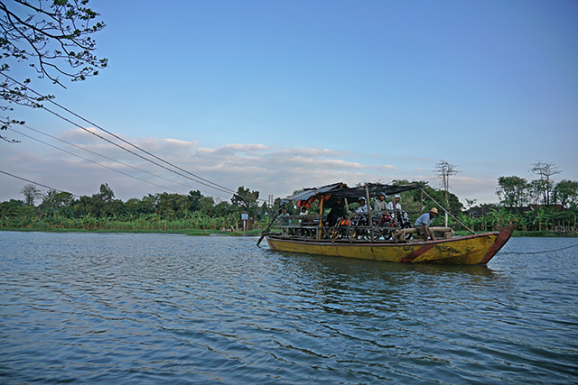 DARURAT: Warga menaiki perahu tambangan untuk menyeberang di Mrican yang jembatannya ambrol sejak 2017 lalu. (Foto: Wahyu Adji)