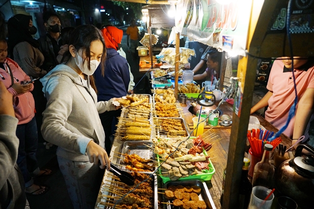 LARIS: Pengunjung angkringan Jl Pattimura memilih berbagai jenis lauk pauk. Buka sejak pukul 16.30 hingga pukul 00.00, omzet yang dihasilkan bisa mencapai jutaan rupiah. (Foto: Wahyu Adji)