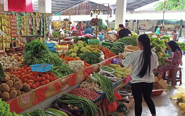 PICU INFLASI: Pedagang Pasar Setonobetek menata sayur mayur di lapak. Komoditas yang stoknya terancam turun di musim kemarau ini bisa mengerek inflasi. (Habibah A. Muktiara/JPRK)