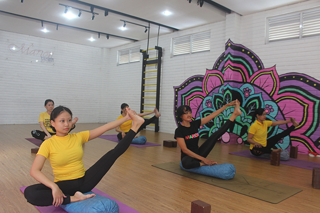 HILANGKAN STRES: Peserta yoga melakukan salah satu gerakan yang dapat melenturkan badan dan menghilangkan tekanan pikiran. (Foto: Ilmidza Amalia)