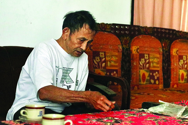 SESEPUH DESA: Mbah Saidi saat menghitung hari baik dengan koin. (Foto: Radar Nganjuk)