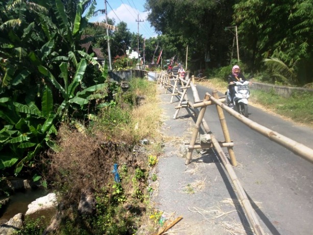 HATI-HATI: Pengendara sepeda motor melintasi jembatan yang rusak di Dusun Sidodadi, Desa Canggu, Kecamatan Badas (6/8). (Foto: Khalqinus Taaddin)