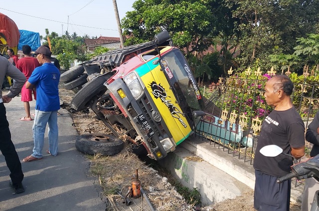 BERANTAKAN: Kondisi truk yang mengalami kecelakaan dan menabrak pagar rumah di pinggir jalan Desa Kunjang, Kecamatan Ngancar kemarin. (Khalqinus Taaddin/JPRK)