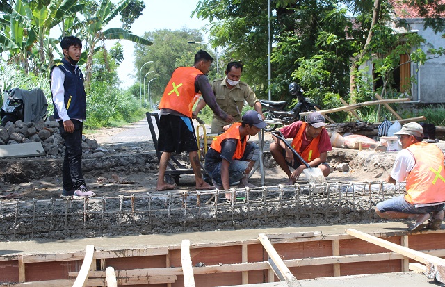JALUR ALTERNATIF: Sejumlah pekerja memperbaiki alas landasan jembatan yang rusak di Jalan Kenanga, Kelurahan Tempurejo, Kecamatan Pesantren kemarin. (Ilmidza Nadzira/JPRK)