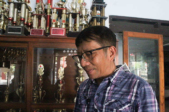 JEJAK PRESTASI: Gandung Satriono di depan lemari piala kejuaraan basket.  (Foto: Iqbal Syahroni)