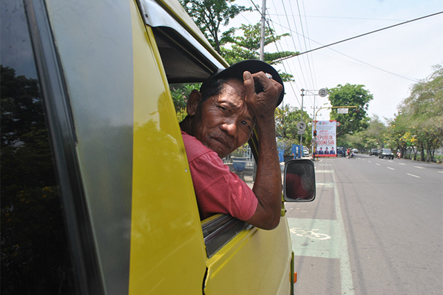 PUSING: Jaelani ngetem di depan Terminal  Nganjuk kemarin. Beberapa sopir MPU  memutuskan pensiun karena harga solar naik. (Foto: Karen Wibi)