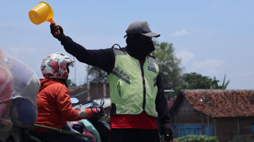 UPAHNYA NASI BUNGKUS: Warga swadaya menjadi penjaga perlintasan kereta api tanpa palang pintu. (Foto: Karen Wibi)