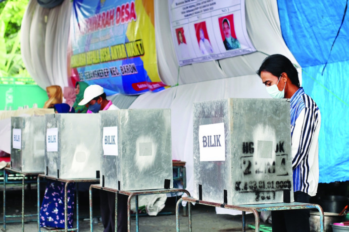 PEMUNGUTAN SUARA: Perwakilan warga Desa Gebangkerep, Kecamatan Baron mencoblos di bilik suara kemarin. Tiga Cakades Gebangkerep bertarung. (Foto: Andhika Attar - Karen Wibi)