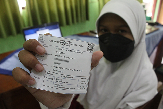 KUNCI: Siswa menunjukkan kartu berisi user dan password untuk login ANBK. (Foto: Rekian)