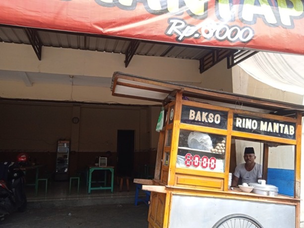 SEPI:PenjualbaksodekatJembatanBandarngalimmenunggupelanggannya di Jalan KH Hasyim Asy’ari, Kelurahan Bandarkidul, Kecamatan Mojoroto. (Foto: Fildatul Halwa)