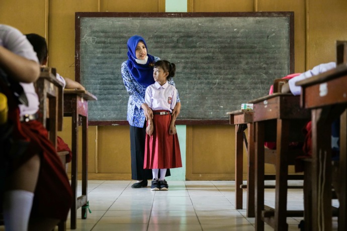 SABAR: Guru SDN Grogol 3 mengajar siswa kelas I. Kesenjangan pendapatan guru PNS dan non-PNS masih jadi PR bagi pemerintah. (Foto: Wahyu Adji)