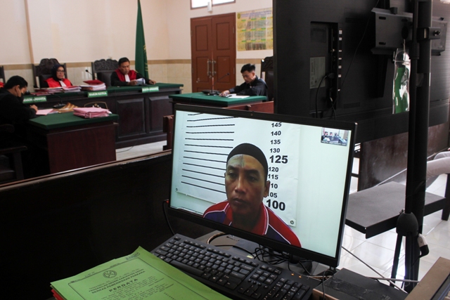 MASIH PIKIR-PIKIR: Terdakwa Agus Hermawan menjalani sidang putusan melalui layar monitor di Pengadilan Negeri Kabupaten Kediri kemarin. (Foto: Khalqinus Taaddin)