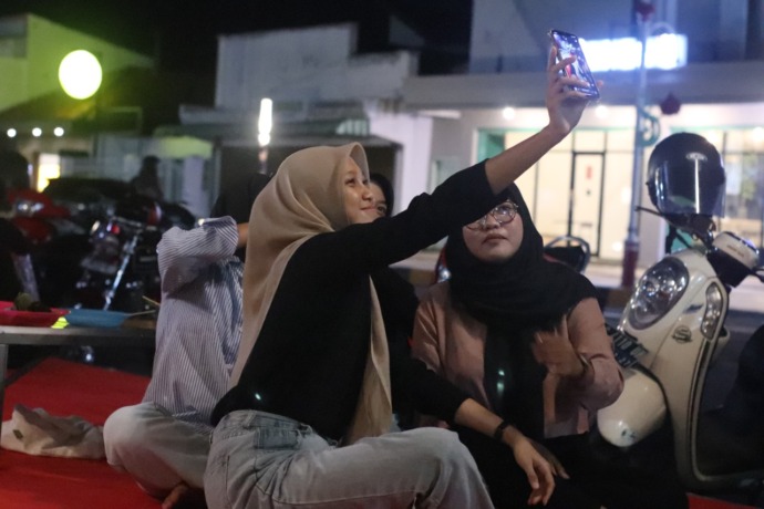NONGKRONG ASIK: Pengunjung Kawasan Ekonomi Nganjuk (KEN) wefie saat lesehan sambil menikmati menu angkringan di Jalan A. Yani Nganjuk kemarin malam. Penjual angkringan menyediakan berbagai macam minuman dan makanan. (Foto: Karen Wibi)