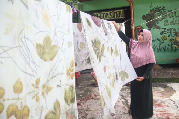 LAGI NGETREN: Perajin batik ecoprint menjemur. Omzet penjualan batik ecoprint di gerai Yayuk mencapai puluhan juta dalam sebulan. (foto: Karen Wibi)