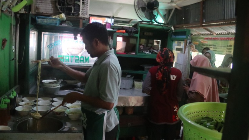 TAAT PAJAK: Pasutri Yanto dan Yanti pemilik warung Mi Ayam Mastrip melayani pembeli kemarin. Mereka menyetor PPN setiap bulan sekitar Rp 10 juta ke Bapenda Kabupaten Nganjuk. (Foto: Karen wibi)
