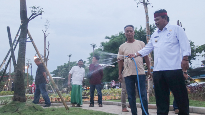 SIDAK: Plt Bupati Marhaen Djumadi menyiram tanaman saat sidak kemarin. Minggu pagi Taman Nyawiji diresmikan. (Foto: Karen Wibi)