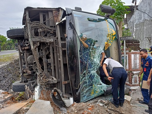 PERIKSA KERUSAKAN: Petugas dishub dan satlantas memeriksa kondisi bus yang terguling karena kecelakaan tunggal di Dusun Munenglor, Desa Muneng, Kecamatan Purwoasri (26/1). (Foto: Habibah A. Muktiara)