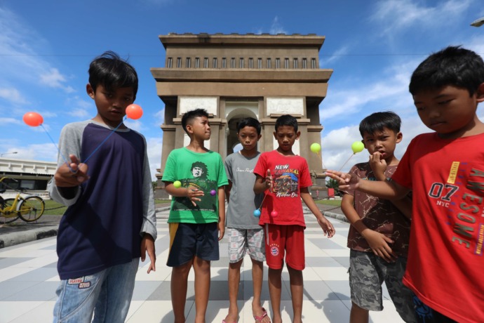 BATTLE: Sejumlah anak memainkan latto-latto di pelataran Simpang Lima Gumul. Anak yang bisa memainkan dua bola bundar itu dalam waktu paling lama jadi pemenangnya. (Foto: Wahyu Adji)