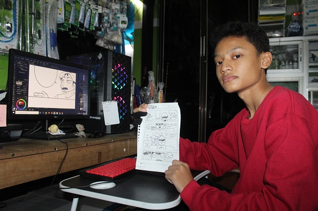 MANUAL: Radit menunjukkan karya komik yang dia buat secara manual. Remaja ini juga membuat komik digital. (Foto: Rekian)