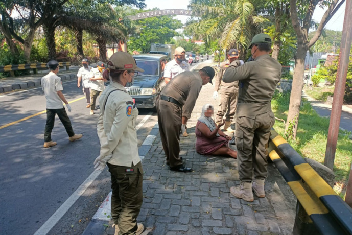BIKIN RESAH: Petugas Satpol PP Kabupaten Nganjuk mengamankan Las di Jembatan Kertosono kemarin. Las sering melempar batu ke pengguna jalan yang melintas di sana. (Foto: Karen Wibi)
