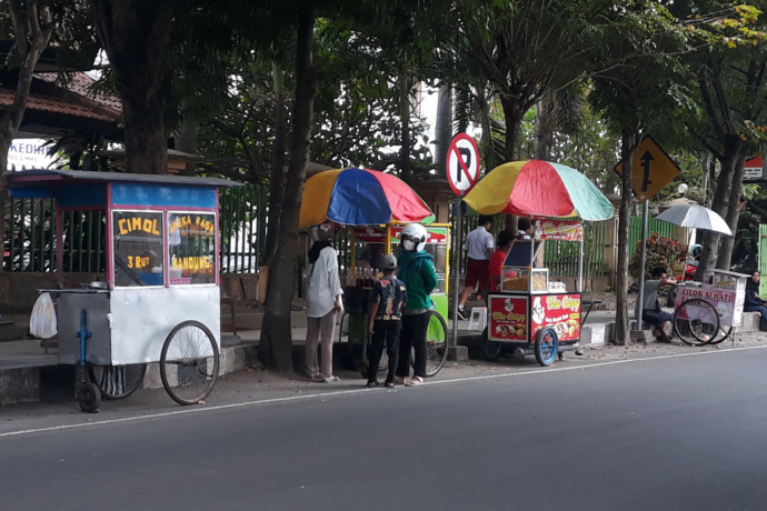 CUACA MENDUNG: Pedagang kaki lima memasarkan dagangannya di Jalan PB Sudirman, Kelurahan/Kecamatan Pare yang terlihat sepi pembeli kemarin. (Foto: Melisa)
