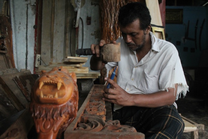 DI BENGKEL KERJA: Hasan Bawazer berada di teras rumahnya yang dia sulap menjadi lokasi workshop. (Foto: Rekian)