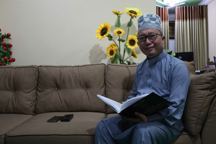 INSPIRATIF: Samsul Hadi membaca buku di ruang kerjanya kemarin. (Foto: Wahyu Adji)