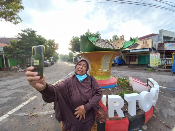 MENGALAMI PERBAIKAN: Warga selfie di depan Tugu Pecel Kertosono. Perbaikan tugu dilakukan setelah banyak komplain dari masyarakat. (Foto: Andhika Attar)