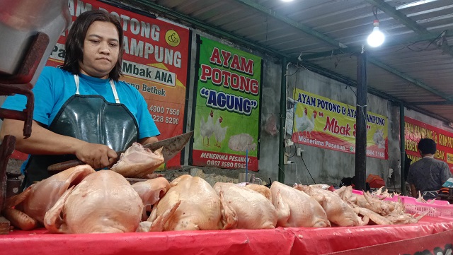 TERUS NAIK: Pedagang memotong daging ayam yang ditawarkan pada konsumen di Pasar Setonobetek, Kota Kediri. (Foto: Asad M.S)