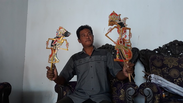 URI-URI BUDAYA: Brodin memegang dua anak wayang krucil miliknya, ketika ditemui di rumahnya, di Desa Bulupasar, Kecamatan Pagu. Dia adalah satu dari tiga dalang wayang krucil yang tersisa.