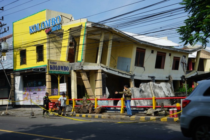 NYARIS AMBRUK: Hotel Kolombo terlihat miring setelah fondasinya tergerus Sabtu (25/3) malam lalu. BPBD meminta polisi memasang police line di lokasi bangunan yang bisa ambruk sewaktu-waktu tersebut. (Foto: Ayu Isma)