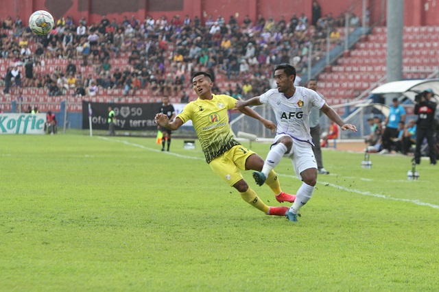 CLEARANCE: Agil Munawar memenangkan duel perebutan bola dengan pemain Barito Putera di Stadion Brawijaya beberapa waktu lalu. (Foto: Iqbal Syahroni)