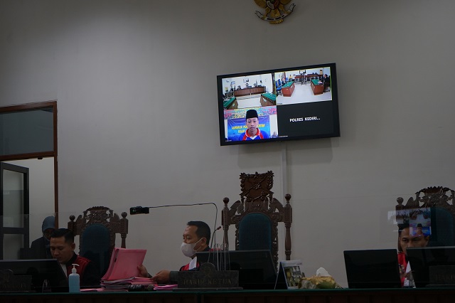HADAPI TUNTUTAN: Valederama Cahya mengikuti persidangan telekonferensi melalui layar monitor di PN Kota Kediri kemarin. (Foto: Habibah A. Muktiara)