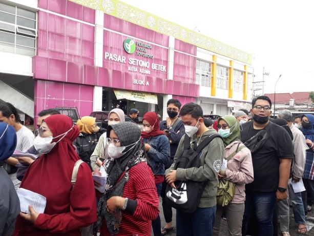 ANTUSIAS: Puluhan orang mengantre untuk menukarkan uang dengan pecahan uang baru jelang Lebaran melalui mobil kas keliling BI Kediri di area parkir Pasar Setonobetek, Kota Kediri kemarin. (Foto:  Ayu Isma)