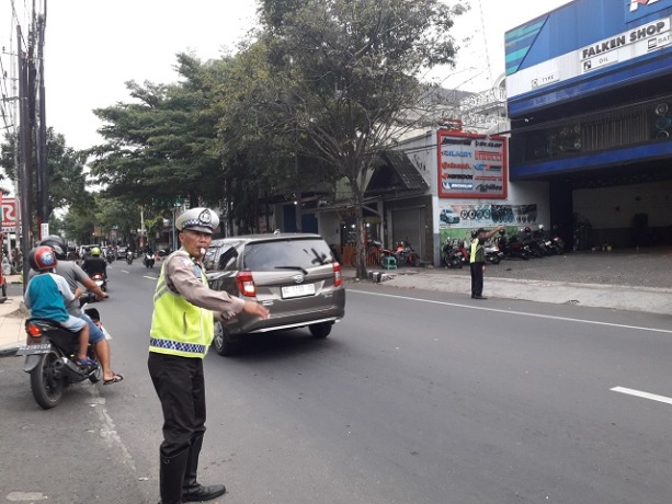ARUS LANCAR: Petugas satlantas polresta mengatur arus lalu lintas kendaraan di Jalan Panglima Sudirman, Kota Kediri kemarin. (Foto: Ayu Isma)