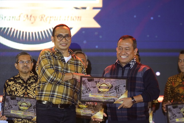 APRESIASI: Direktur Jawa Pos Radar Kediri Kurniawan Muhammad menyerahkan penghargaan kepada Kepala SMAN 2 Kota Kediri Drs H Sarbawa MPd. (Foto: Wahyu Adji)