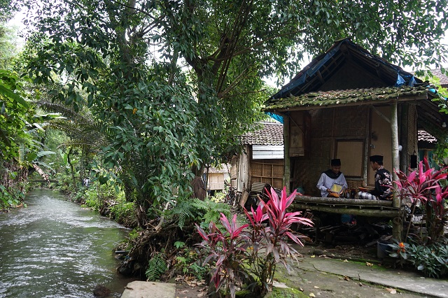 TENANG: Sejumlah santri Ponpes Mahir Arriyadl Ringinagung mengaji kitab di saung tepi sungai. (Foto: Wahyu Adji)