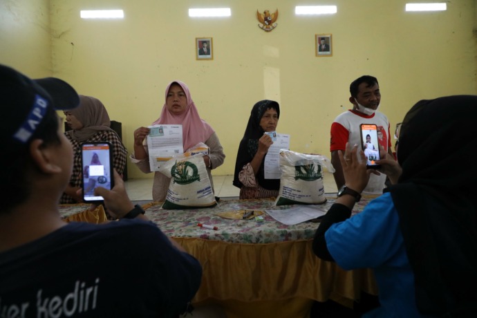KUALITAS BAGUS: Warga Desa Maron antusias mengambil jatah bantuan pangan CPB berupa 10 kilogram beras yang disalurkan di tiga kecamatan barat sungai secara serentak kemarin. (Foto: Wahyu Adji)