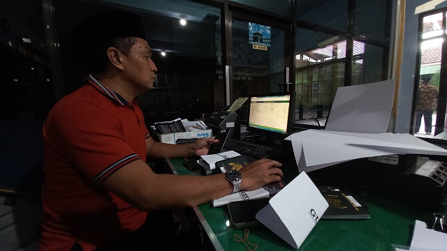 TELITI: Staf Seksi PHU Kantor Kemenag Kabupaten Kediri memeriksa paspor calon jemaah haji. Waktu pelunasan biaya haji kini diperpanjang hingga Jumat (12/5). (Foto: Andhika Attar/JPRK)