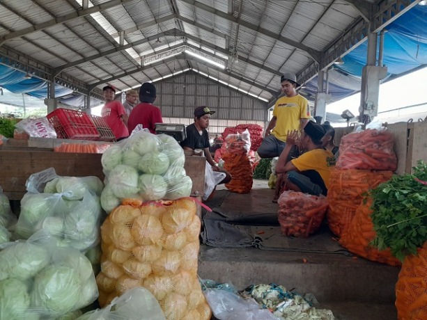 MERANGKAK NAIK: Para pedagang di Pasar Induk Pare sedang menunggu pembeli sambil bercengkrama kemarin. Harga beberapa komoditas sayuran mengalami kenaikan harga. (Foto: Emilia Susanti/JPRK)