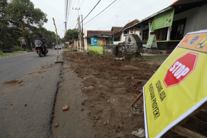 DIKEBUT: Rekanan proyek pelebaran jalan Banyakan-Bolawen mulai menggali tanah di sisi kanan dan kiri jalan. Proyek ditarget tuntas sebelum 17 Agustus nanti. (Foto: Wahyu Adji)