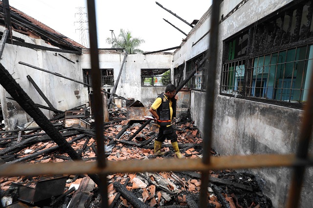 CARI BUKTI: Personel Labfor Polda Jatim memeriksa tiga lokal gedung DKPP Kota Kediri yang terbakar pada Sabtu (30/4) lalu. Petugas mengumpulkan barang bukti untuk menyelidiki penyebab kebakaran. (Foto: Wahyu Adji)