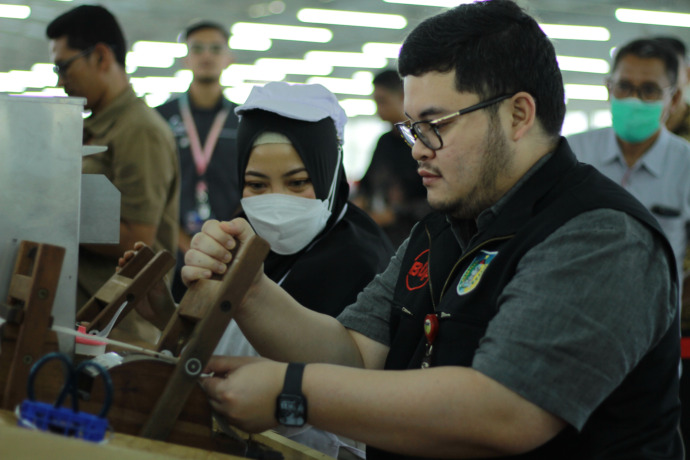 SULIT: Bupati Hanindhito Himawan Pramana belajar melinting rokok kretek saat sidak ke pabrik rokok Apache di Kecamatan Pare kemarin. (Foto: Andhika Attar)